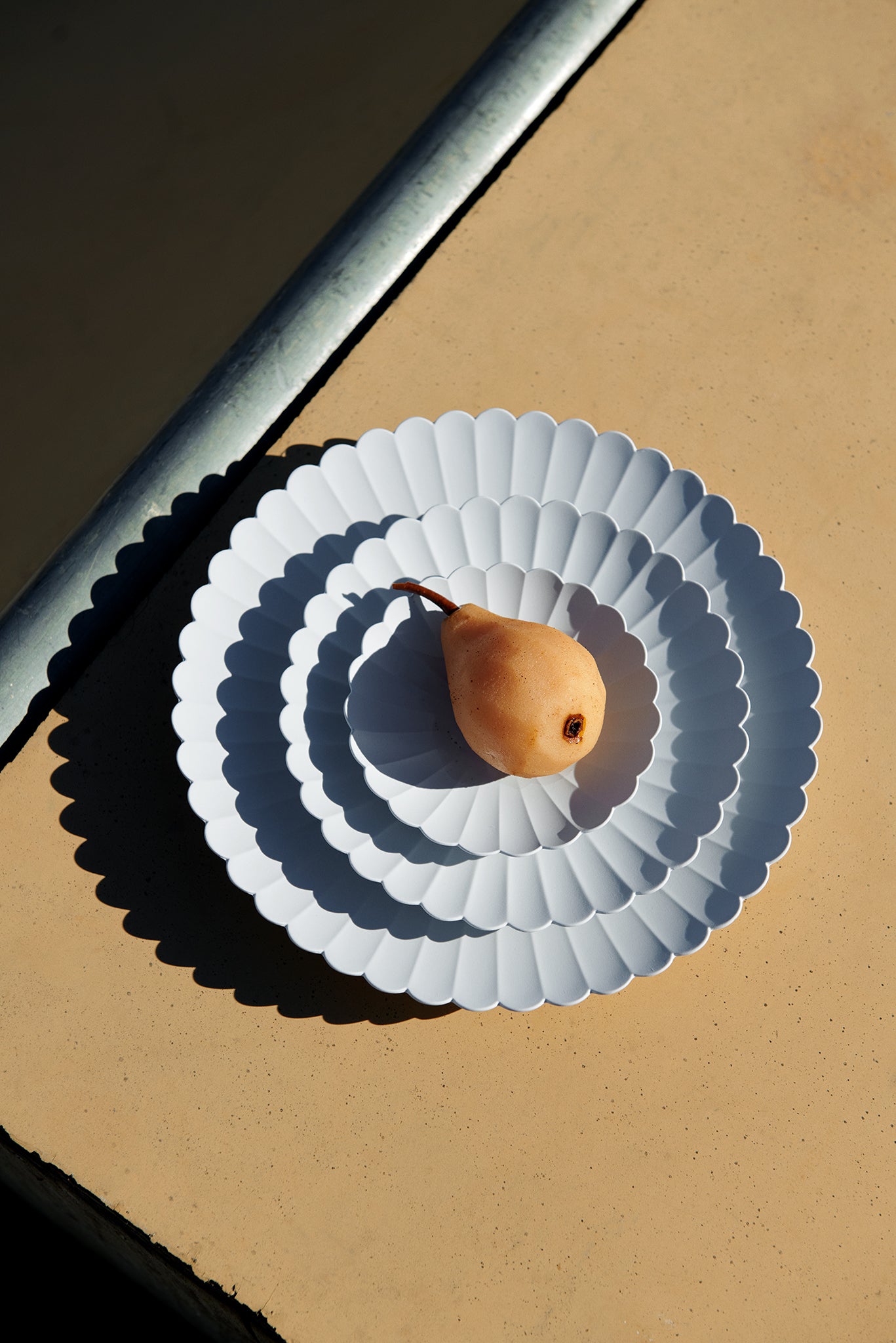 verschieden große Teller gestapelt auf einem Tisch. Die Marke der Produkte ist 1616/ Arita vom Designer Teruhiro Yanagihara. Die Teller heißen Palace Plates.