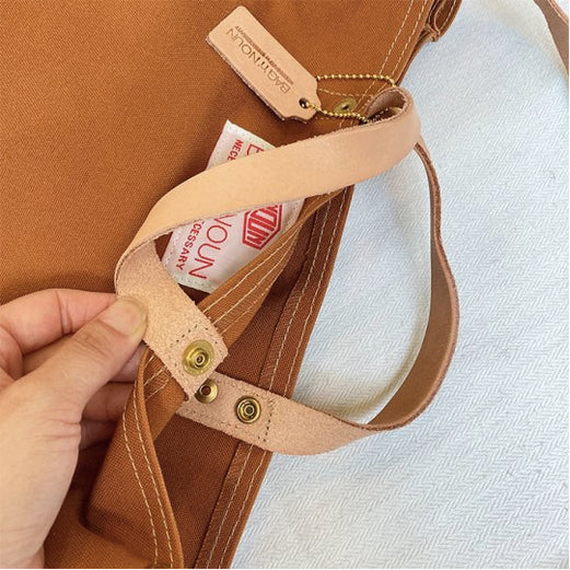 Verschluss einer braunen Tasche von BAG'n'NOUN, das Modell heißt Duck Toolbag, die Farbe heißt Gold