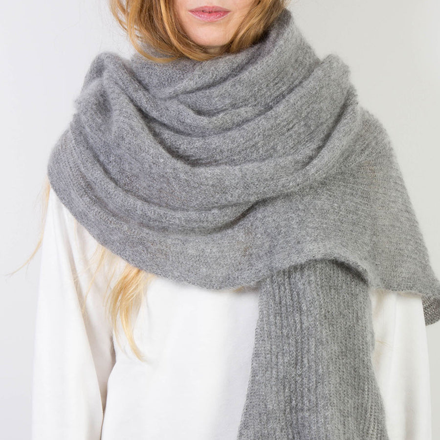 Person trägt Grau melierten, großen gestrickten Mohairschal.