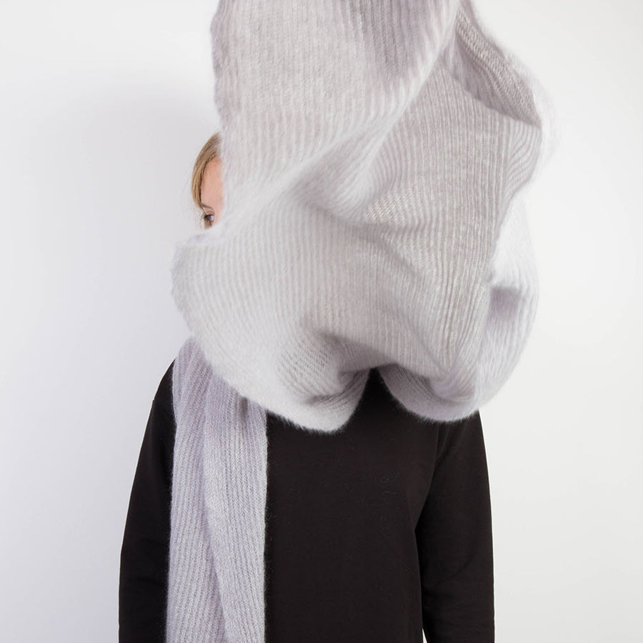 Person trägt hellgrauen, großen gestrickten Mohairschal.