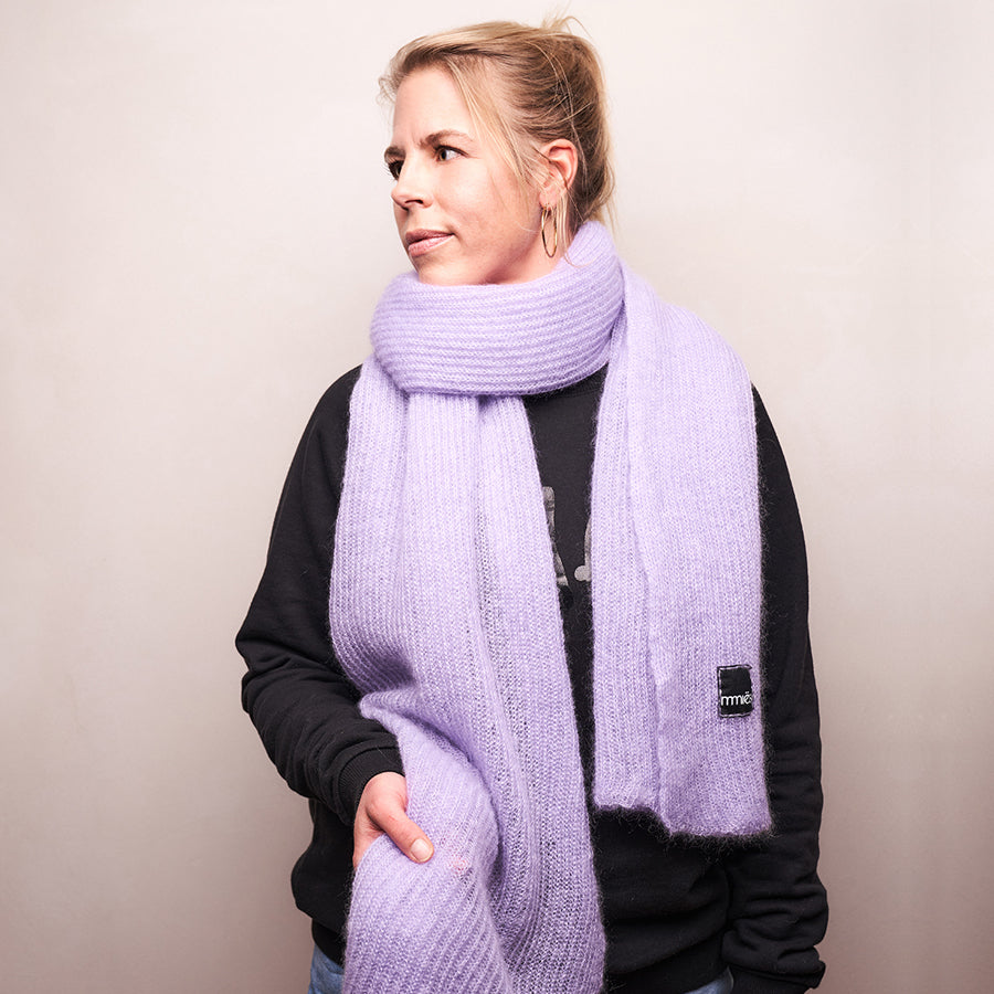 Person trägt Lilafarbenen großen gestrickten Mohairschal.