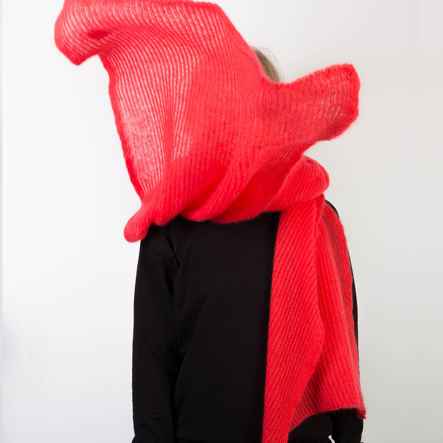 Person trägt orange-pinken, großen gestrickten Mohairschal.