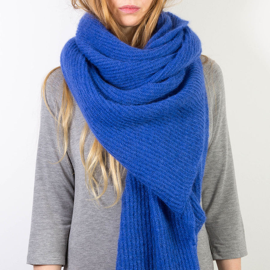 Person trägt royalblauen, großen gestrickten Mohairschal.