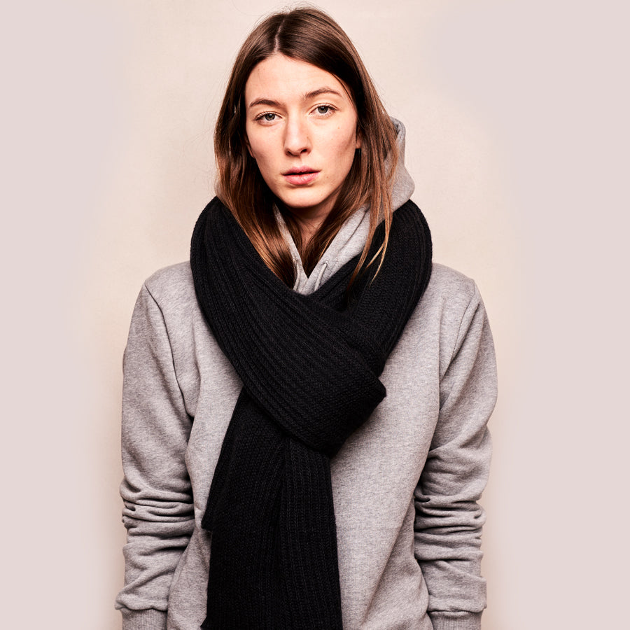 Person trägt schwarzen, großen gestrickten Mohairschal.