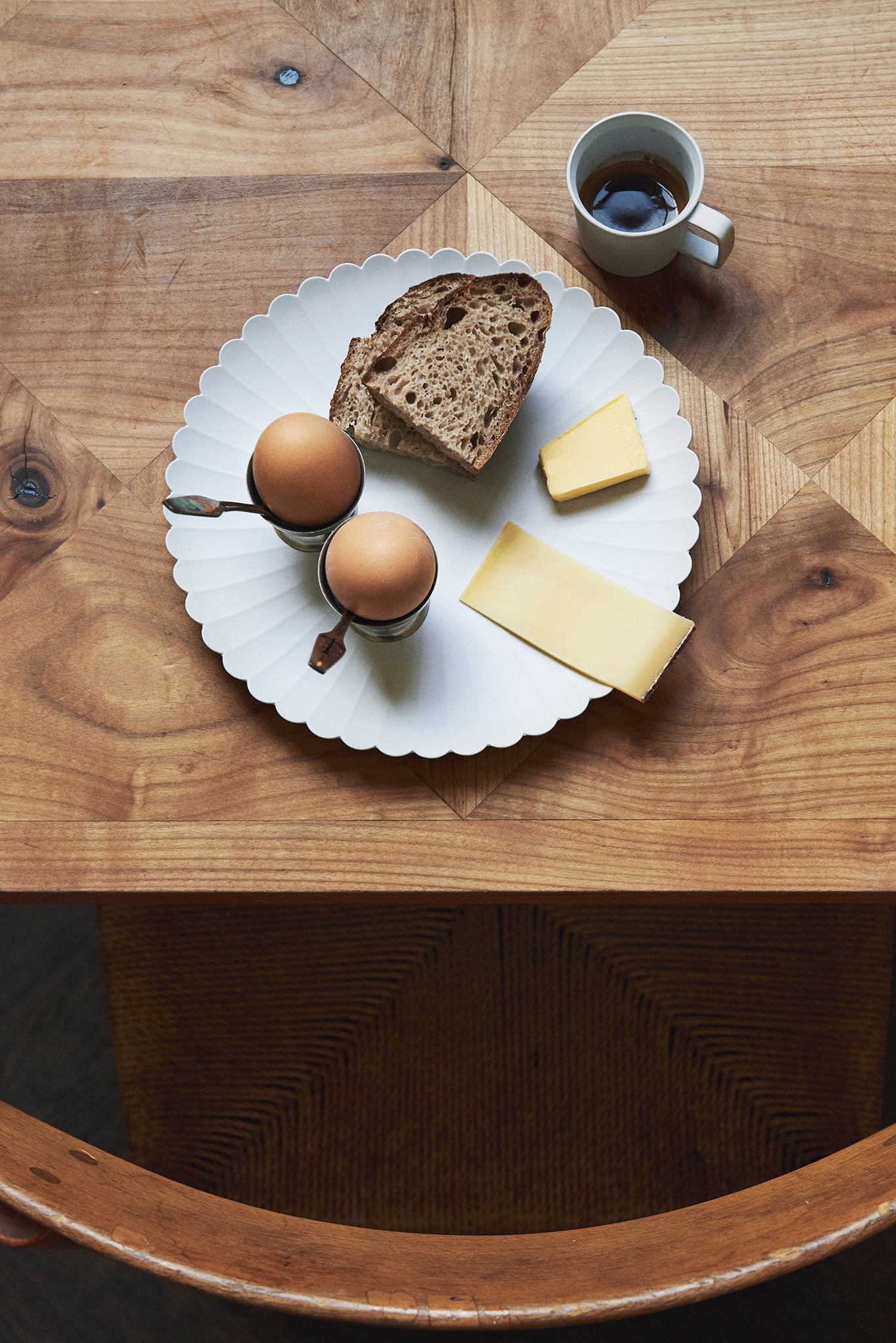 Frühstücksteller Teller mit Brot, Ei und Käse auf einem Tisch. Die Marke ist 1616/ Arita vom Designer Teruhiro Yanagihara. Der Teller heißt Palace Plate 220.